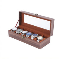 Boîte à Montres 6 Compartiments – Ranelagh, vue de trois quarts sur fond clair, finition brun foncé, avec montres
